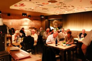 a group of people sitting at tables in a restaurant at Hotel zum Taufstein in Sparhof