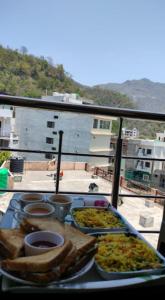 a tray of food on a table on a balcony at Athalia guesthouse in Rishīkesh