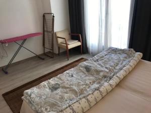 a bed in a room with a chair and a window at Akçakoca'da Şirin Küçük Daire in Duzce