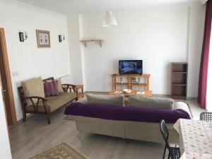 ein Wohnzimmer mit einem Sofa und einem Tisch in der Unterkunft Akçakoca'da Şirin Küçük Daire in Duzce