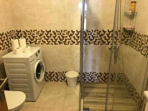 a bathroom with a shower and a washing machine at Akçakoca'da Şirin Küçük Daire in Duzce