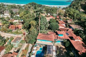 - une vue aérienne sur un village avec des maisons et l'océan dans l'établissement Pousada Villa Atlântica, à Camburi