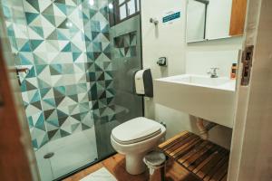 a bathroom with a toilet and a sink and a shower at Pousada Villa Atlântica in Camburi