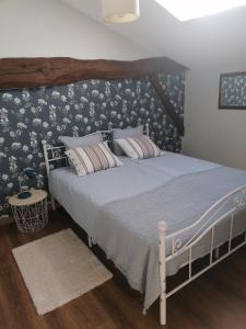 una camera da letto con un grande letto e carta da parati floreale di Le Verger du Paradis a Beaulieu-sur-Sonnette