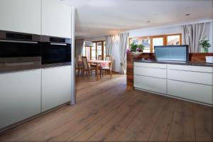 a kitchen with white cabinets and a dining room at Sonnenschein in Bischofswiesen