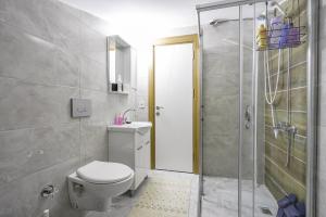 een badkamer met een douche, een toilet en een wastafel bij Modern Flat w Balcony 5 min to Beach in Kemer in Antalya