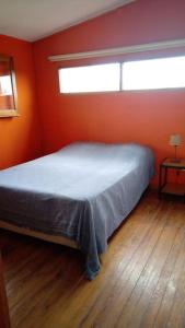 - une chambre dotée d'un lit avec un mur orange dans l'établissement Cruz de Caña "La Casa del Río", à Cruz de Caña