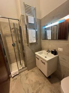 uma casa de banho com um lavatório, um chuveiro e um WC. em Independent Rooms Apartment - ST TERMINI em Roma