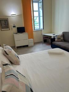 um quarto com uma grande cama branca e um sofá em Independent Rooms Apartment - ST TERMINI em Roma