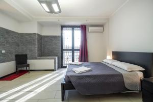 a bedroom with a large bed and a window at Royal Playa Suite and Apartament -private parking- self chek out in Catania