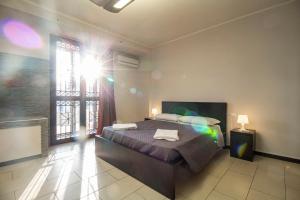 1 dormitorio con 1 cama en una habitación con ventana en Royal Playa Suite and Apartament -private parking-, en Catania