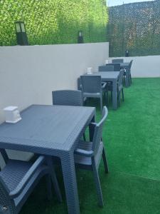 een rij tafels en stoelen met groen gras bij istanbul airport family suites hotel in Arnavutköy