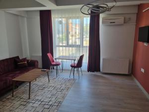 ein Wohnzimmer mit einem Sofa, einem Tisch und Stühlen in der Unterkunft istanbul airport family suites hotel in Arnavutköy