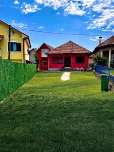 a red house and a yellow house with a yard at Apartman K2 in Kraljevo