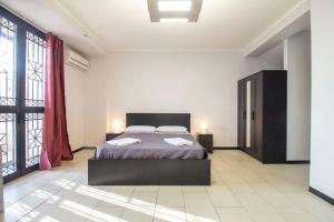 a bedroom with a bed and a large window at Royal Playa Suite and Apartament -private parking- self chek out in Catania