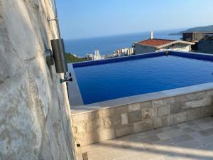 a swimming pool on the side of a building at Fimas Sea View Residence & Pool Bečići in Ivanovići