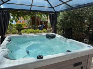 a jacuzzi tub with a canopy in a yard at Vacation House Marin with Jacuzzi - Bol, Brač in Bol