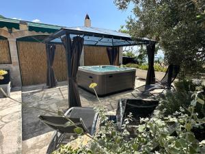 a hot tub under a gazebo in a garden at Vacation House Marin with Jacuzzi - Bol, Brač in Bol