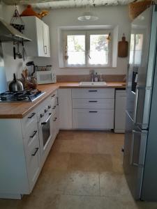 una cucina con mobili bianchi e un lavandino di Le Mazet de l'Acacia a Beaumes-de-Venise