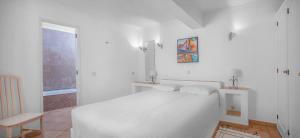 a white bedroom with a white bed and a window at 2 Bed Flat - Sleeps 4 - Pool - Terrace - Parking in Luz