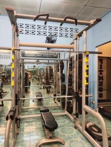 a gym with rows of equipment and weights at SK Hometel Samui Airport in Bangrak Beach