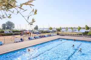 a pool at a hotel with people in the water at Veerse Meersuites in Kortgene