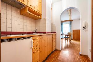 una cocina con armarios de madera y un arco en Lindenhof Apt 6, en Vandoies