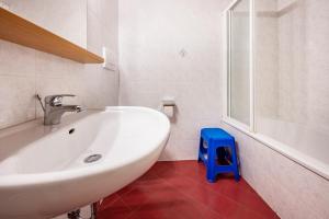 baño con lavabo blanco y taburete azul en Lindenhof Apt 6, en Vandoies