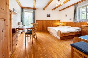 1 dormitorio con cama y escritorio en Lindenhof Apt 6, en Vandoies