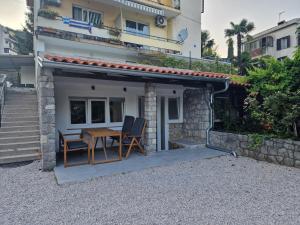 a small house with a table and chairs outside at Apartment Luce in Lovran