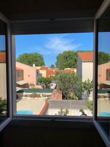 ein Fenster in einem Zimmer mit Blick auf einen Innenhof in der Unterkunft Maison Toulouges Climatisée - Proche Perpignan in Toulouges