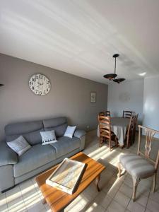 ein Wohnzimmer mit Sofa und Tisch in der Unterkunft Maison Toulouges Climatisée - Proche Perpignan in Toulouges