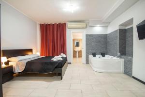 a bedroom with a bed and a bath tub at Royal Playa Suite and Apartament -private parking- self chek out in Catania