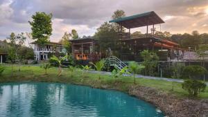 a house with a pond in front of it at ภูอิงนาคาเฟ่&รีสอร์ท in Ban Wang Takhrai