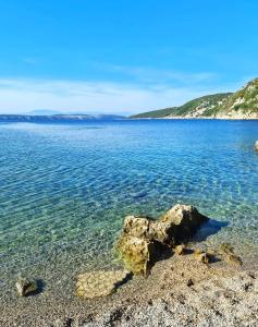 a large body of water with a rock in the shore at Apartments Lucia&Veronica in Dramalj