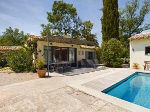 a villa with a swimming pool and a house at MAS DU TEMPS PERDU in Maussane-les-Alpilles