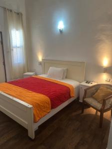 a bedroom with a large bed and a chair at Akko Gate Hostel in Acre