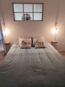 1 cama grande con 2 almohadas con las palabras amor en Coeur de Caux, en Yvetot