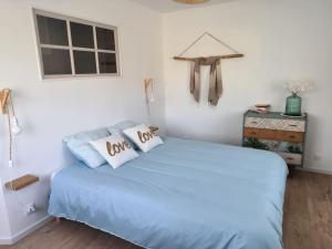 1 dormitorio con 1 cama azul y 2 almohadas en Coeur de Caux, en Yvetot
