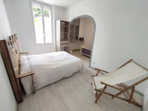een slaapkamer met een bed, een spiegel en een stoel bij Maison au calme avec parking proche centre-ville in Orange