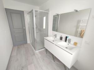 La salle de bains blanche est pourvue d'un lavabo et d'une douche. dans l'établissement Maison au calme avec parking proche centre-ville, à Orange