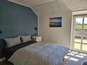 a bedroom with a bed and a window at B&B Hygge Jegindø in Thyholm