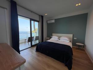 um quarto com uma cama grande e uma janela grande em Beachfront Comfort Apartments SINAJKO em Podgora