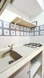a kitchen with a sink and a stove at Praialonga - Attico con terrazzo in Le Castella