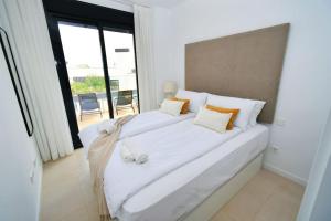 Cette chambre comprend un grand lit blanc et une grande fenêtre. dans l'établissement Casa Kerr - Luxury Apt - Sleeps 9 - Los Boliches, à Malaga