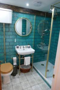 a bathroom with a sink and a toilet and a mirror at Hathaway Hamlet in Stratford-upon-Avon