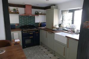 a kitchen with a stove and a sink at Hathaway Hamlet in Stratford-upon-Avon