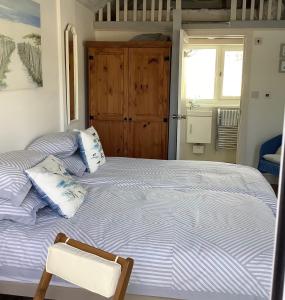 a bedroom with two beds and a chair in it at Ger Tŷ, Reynoldston in Swansea