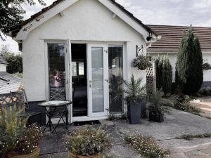 una casa con una puerta blanca y algunas plantas en Ger Tŷ, en Swansea