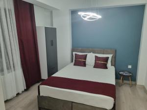 een slaapkamer met een groot bed met paarse kussens bij istanbul airport family suites hotel in Arnavutköy